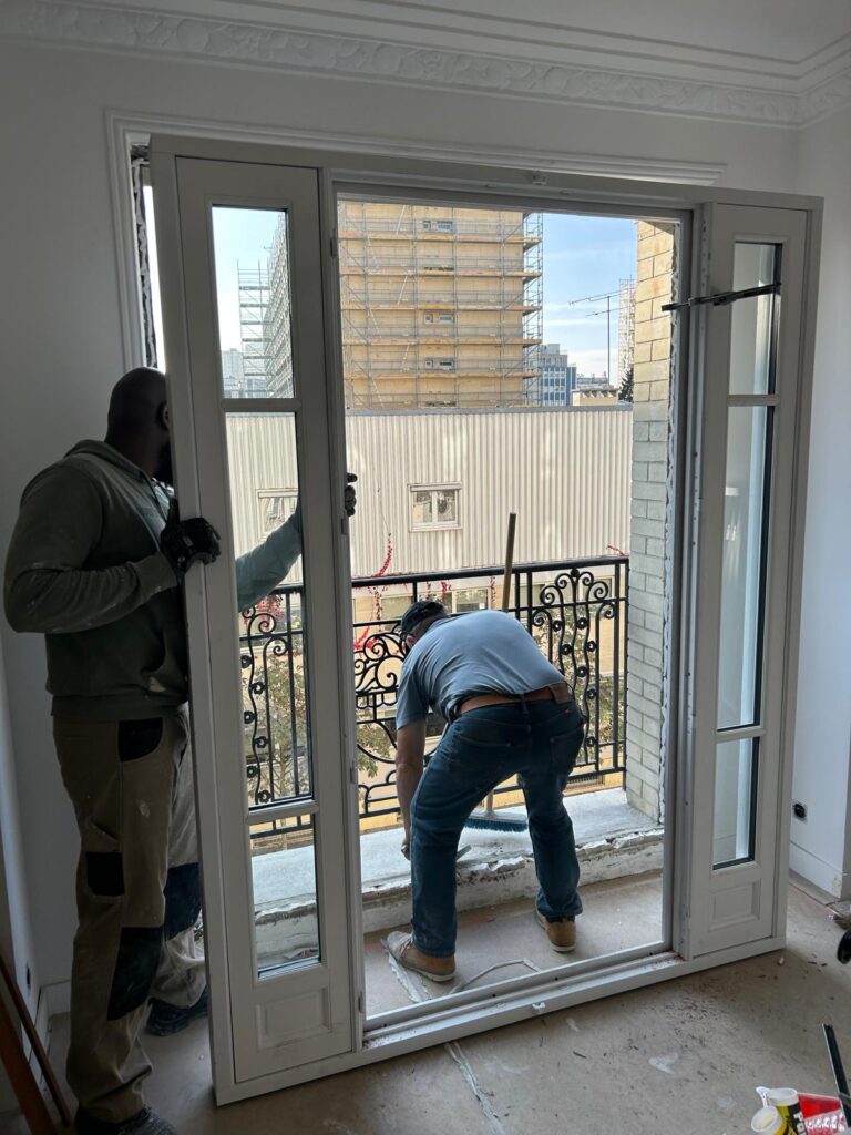 Pose d'une fenêtre par deux compagnons dans un appartement à Paris 5e